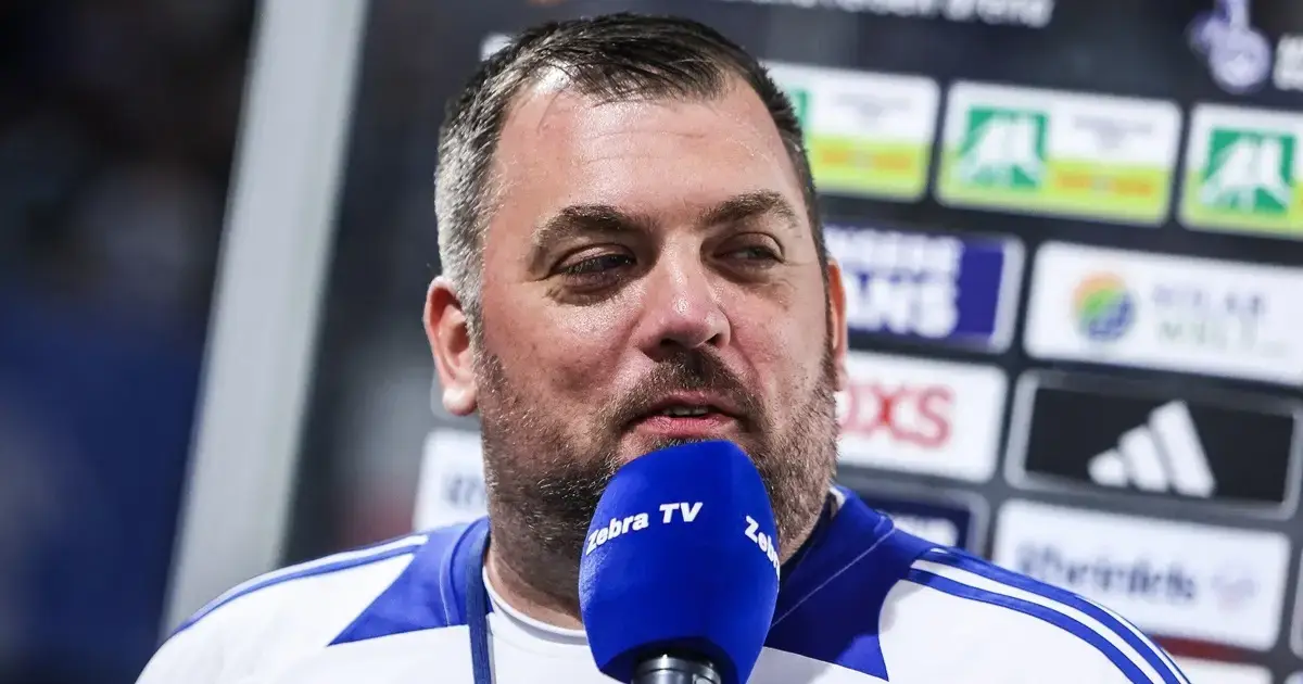 Fragen an Henne im MSV-Trikot spricht bei einem Stadioninterview mit einem blauen Zebra TV-Mikrofon.